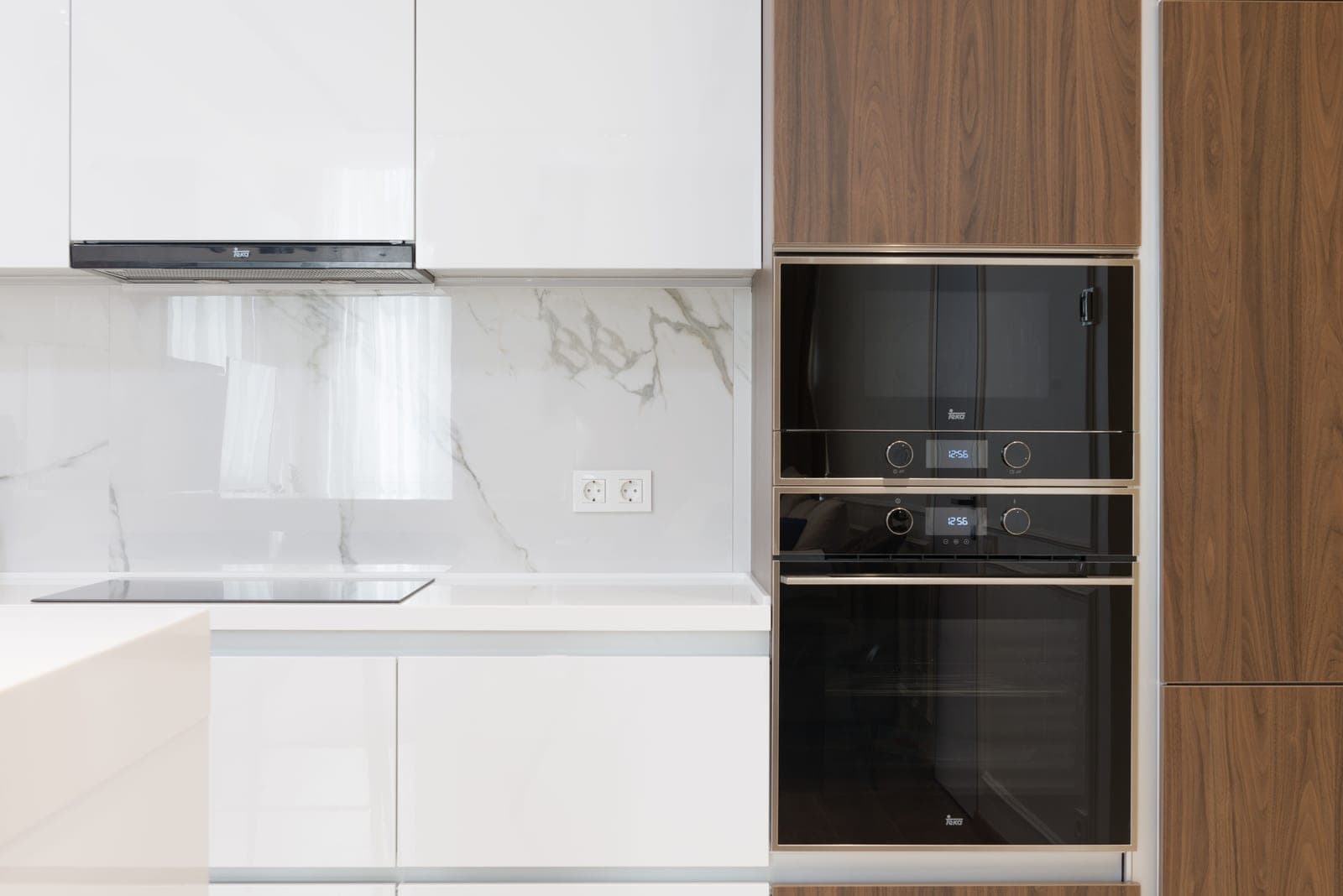A modern white and wood kitchen with built-in appliances