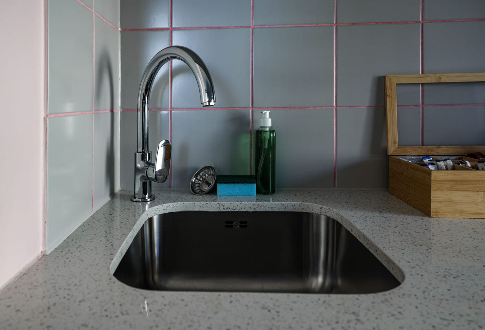 A kitchen sink with a chrome faucet and a clean countertop
