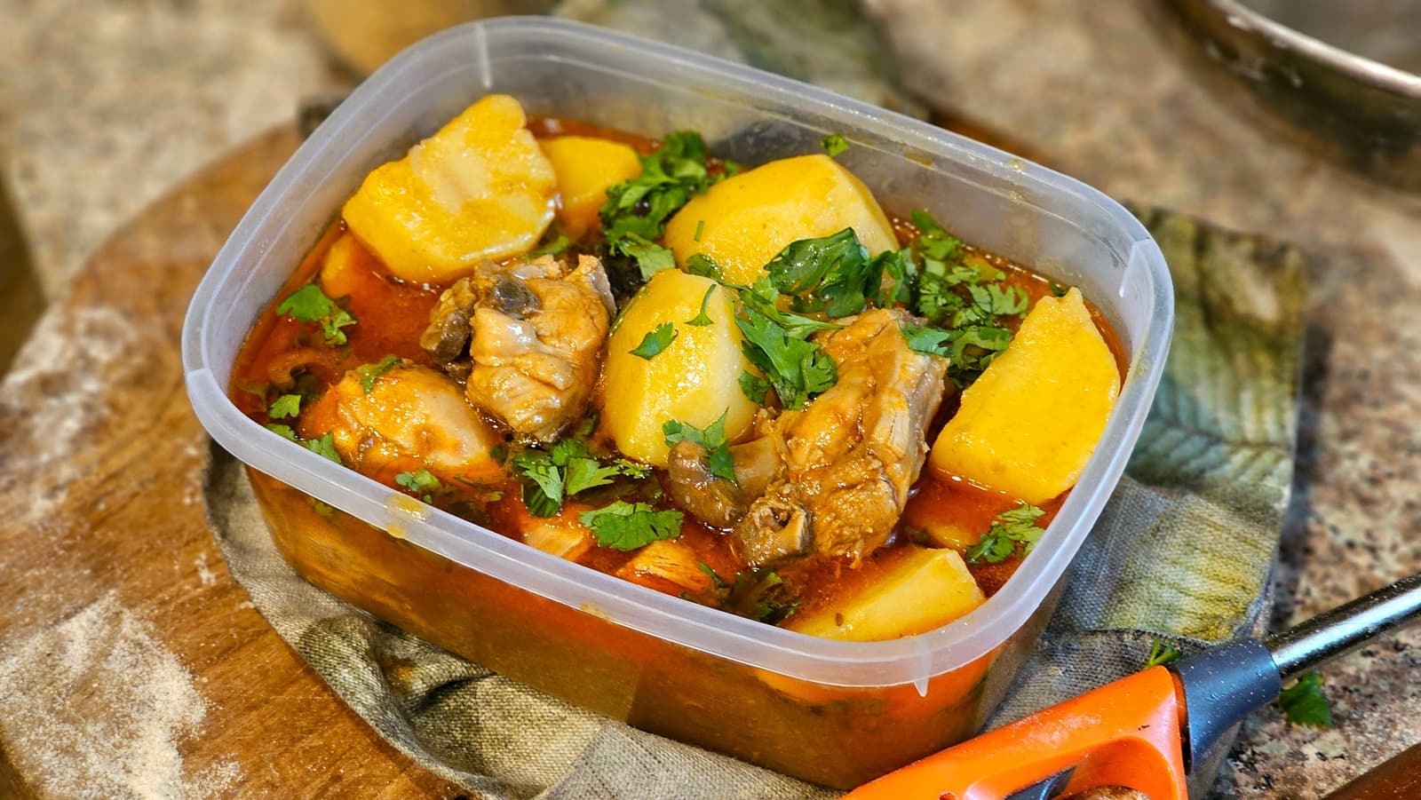 Homemade chicken stew with potatoes in a plastic container