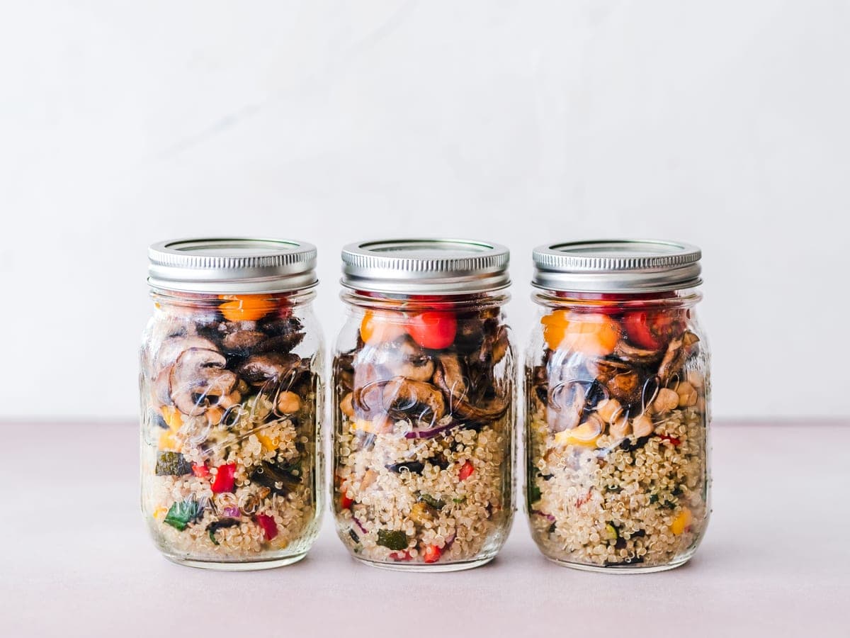 Illustrative stock photo: quinoa salad with roasted vegetables layered in a glass jar