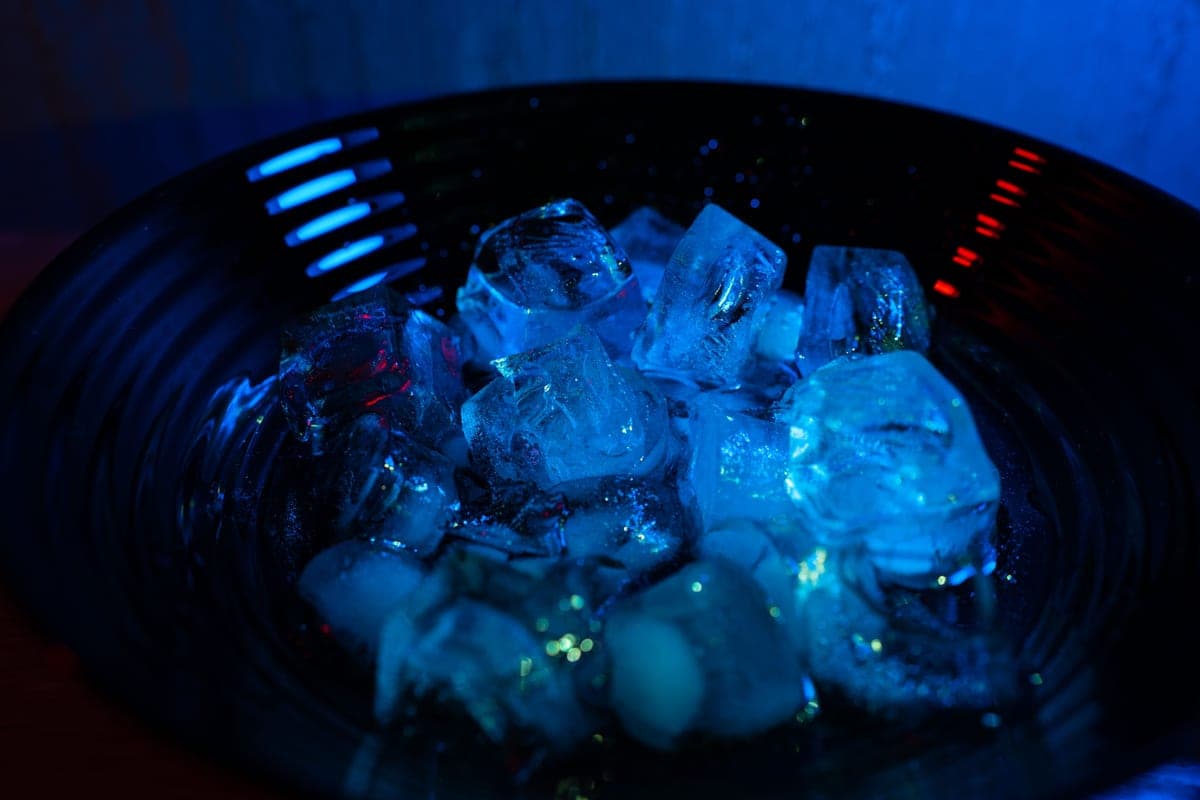 Ice cubes in a bowl under blue and red light