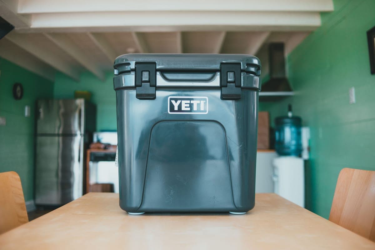 Illustrative stock photo: a hard cooler on a wooden table in a cabin kitchen